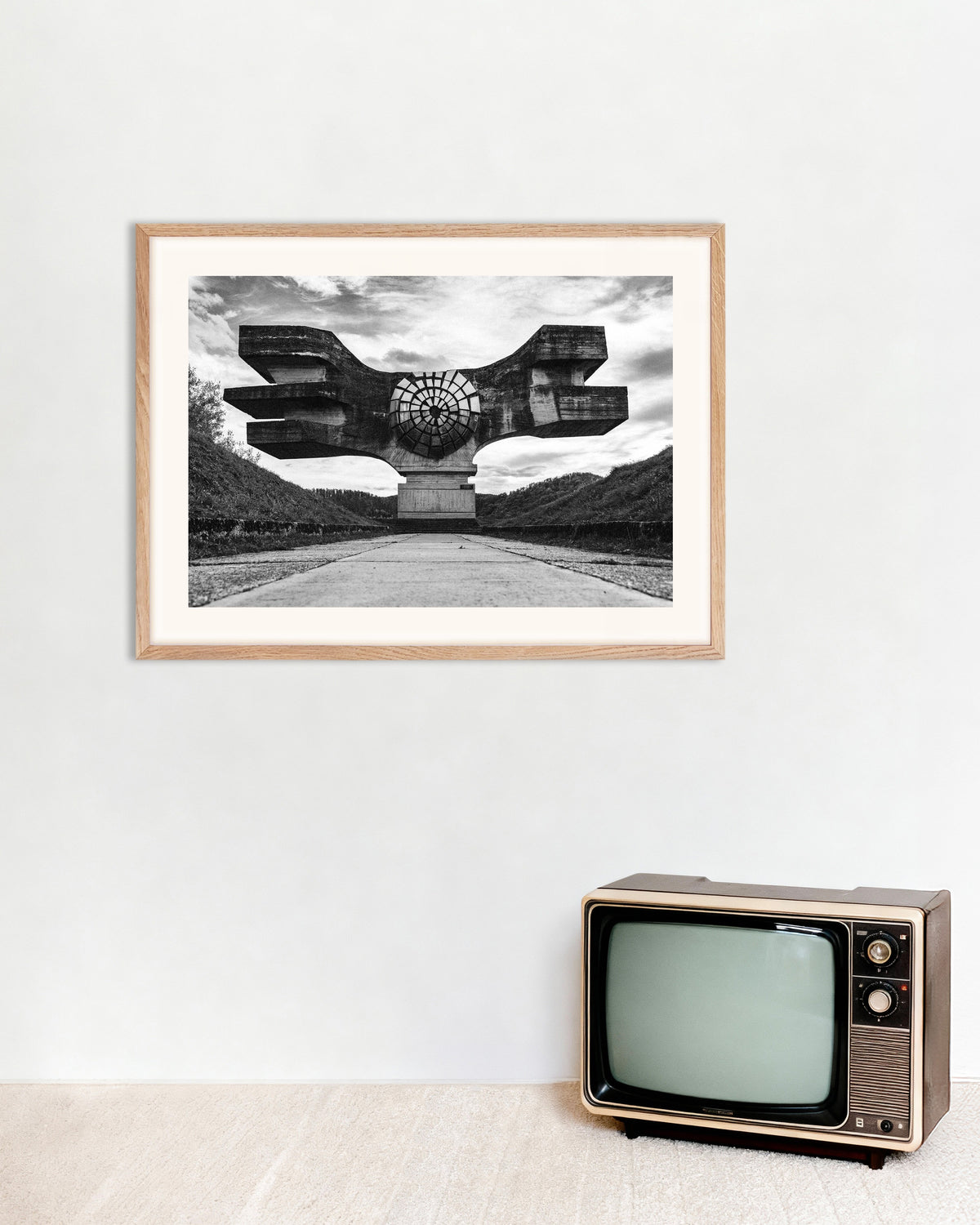 Poster «Monumento Alado no Fim da Estrada», com moldura de madeira natural